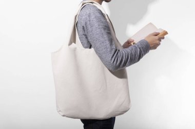 Adam beyaz arka plan üzerinde mockup boş şablon için çanta tuval kumaş tutuyor. küresel ısınma kavramı.