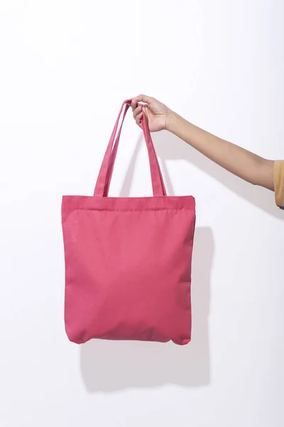 Ragazza è in possesso di tessuto tela borsa rosa per modello vuoto mockup su sfondo bianco. concetto di riscaldamento globale . — Foto Stock