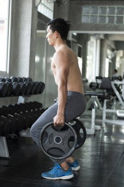 Genç Asyalı adam spor salonunda halter kaldırma. sağlıklı yaşam tarzı ve egzersiz motivasyon kavramı.