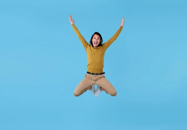 Šťastný Energický Mladý Asijský Muž Skákání Vzduchu Izolované Modrém Pozadí — Stock fotografie