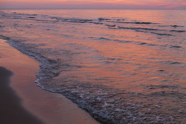 Purple orange sunset Baltic Sea and surf in autumn