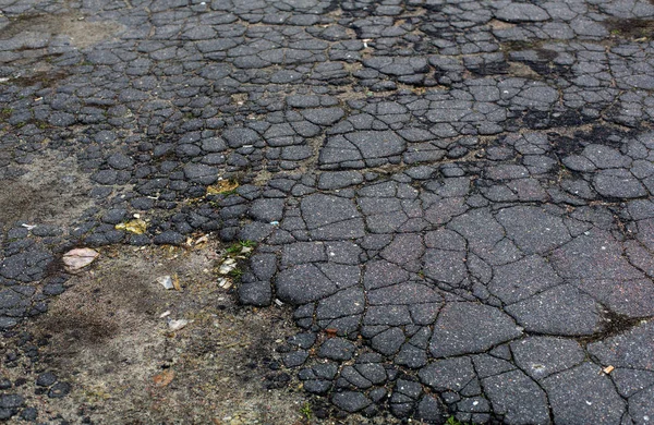 Old aged grey cracked asphalt road surface