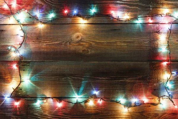 新しい年のフレーム クリスマスの背景 デザイン バナー 木製の背景のランプ色のライトとクリスマスの花輪 本文の空きスペース コピー スペース — ストック写真
