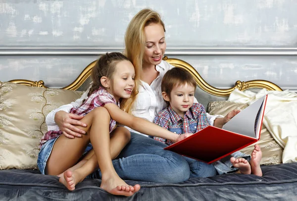 Young white Mom reads a book to her children