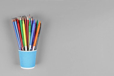 siyah ve beyaz, noir, Minimalizm. Mavi arka plan üzerinde renkli kalemler ile metal sahibi. kavram Okulu, natürmort, uzay kopyalayın. üstten görünüm.