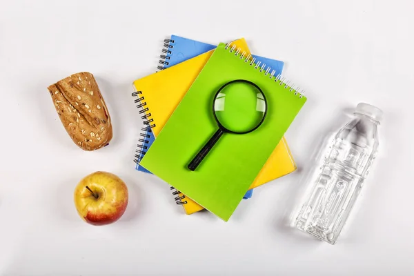 Back to school concept. school snack. Appetizing sandwich, apple in lunch box and magnifier on white background. Free space for text. Copy space. top view