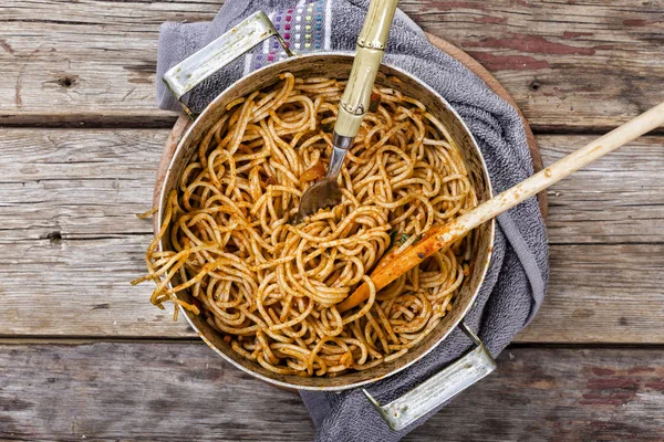 Italian pasta dinner. pan with pasta bolognese on a wooden table. top view. rustic style, copy space