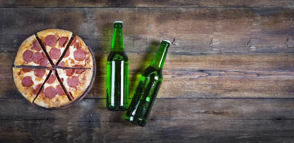 啤酒比萨饼的概念 在酒吧或比萨店顶部的木桌上有啤酒的香肠比萨饼 复制空间 — 图库照片