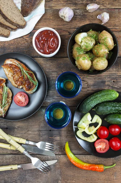 Izgara tavuk biftek sebze ile süslenmiş. Geleneksel Amerikan diner. Kızarmış biftek ve kırmızı şarap, ahşap masa, üstten görünüm, rustik tarzı