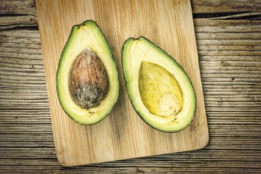 İspanyolca bir kesme tahtası üzerinde ikiye böldüm avokado