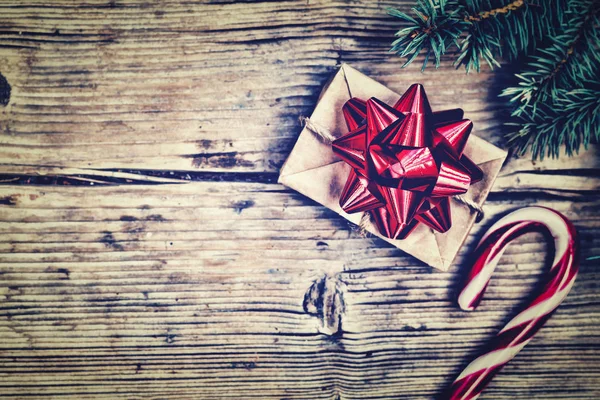 毛皮で覆われたスプルースの枝とクリスマスのお菓子に近い赤い弓と自家製ボックスでギフト飾られてクリスマスまたは新年の背景 — ストック写真