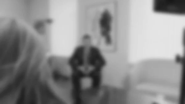 Background image, blur. Politician, congressman gives an interview in his office.