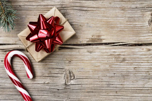 圣诞节 礼品盒与红色弓 圣诞树蓬松的分支和圣诞节糖果糖果在木背景与复制空间 顶视图 — 图库照片