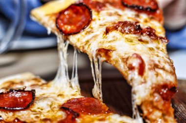 Sıcak pizza dilim peynir erime ile. Bir parça pepperoni pizza closeup. İtalyanca pişirme.