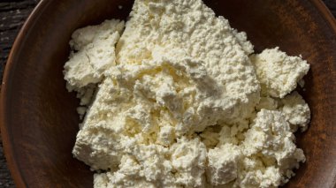 Rustik bir tabloda bir kil kase süzme peynir. Diyet gıda