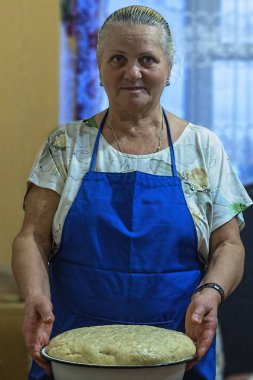 Yaşlı kadın hamur ekmek için hazırlanıyor