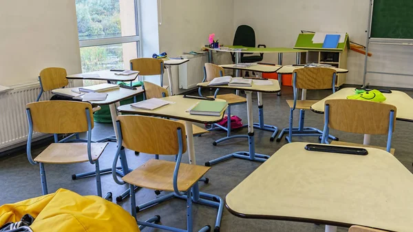 Interior of classroom in the modern school. School board, desks, textbooks. Back to school