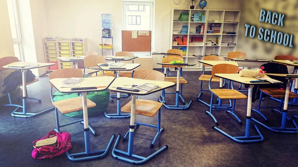 Interior of classroom in the modern school. School board, desks, textbooks. Back to school