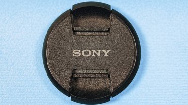 2019, 1 Ocak, Ukrayna, Kiev. Sony dijital fotoğraf makinesi lens kapağı yakın çekim bir mavi Kağıt arka plan. Minimalizm