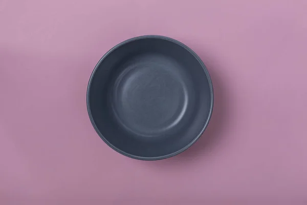 Minimalism. Gray empty bowl on a pink background. Concept: menu, diet, lose weight