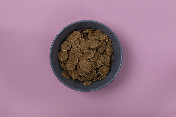 Минимализм. Здоровый завтрак. Серые кукурузные хлопья на розовом фоне. Концепция: меню, диета, похудеть
