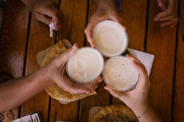 Bira içip bira içen üç mutlu arkadaş. Gençlerle dostluk kavramı. Güzel bir barda birlikte eğleniyorlar. .