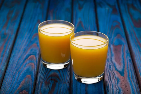 Mavi ahşap arka planda portakal suyu..