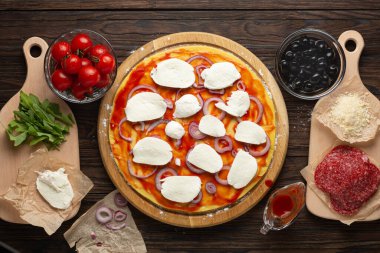 Mozzarella zeytinleri ve salamlı ev yapımı pizza yapma süreci