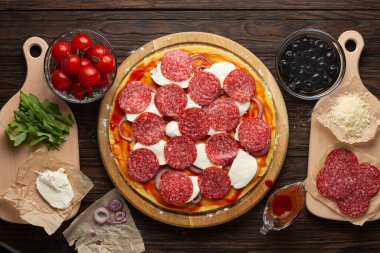 Mozzarella zeytinleri ve salamlı ev yapımı pizza yapma süreci