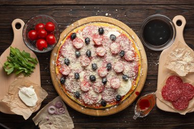 Mozzarella zeytinleri ve salamlı ev yapımı pizza yapma süreci