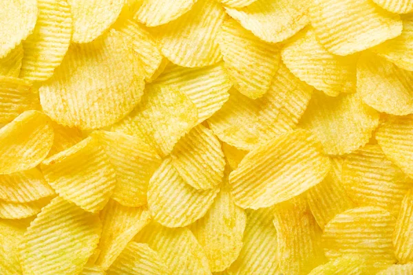 Bakgrund korrugerade gyllene chips med struktur, ovanifrån — Stockfoto