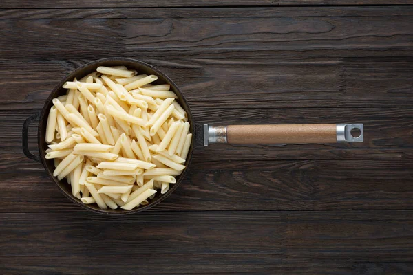 Pâtes italiennes Penne dans une poêle, style rustique vue du dessus — Photo