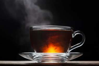 Siyah arka planda bir fincan sıcak İngiliz çayı..