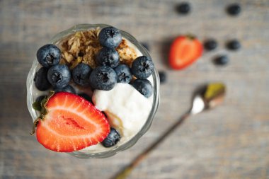 Uzun bardakta çilekli ve yabanmersinli dondurma.