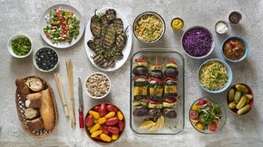 Hafif bir yemek masasında çeşitli vejetaryen yemekleri ve salatalar.