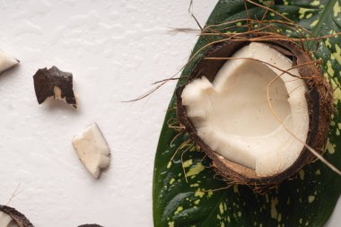 Kırılmış hindistan cevizi parçaları beyaz masaya yakın.