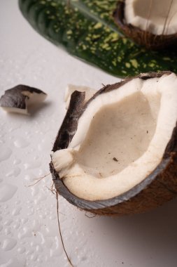 Kırılmış hindistan cevizi parçaları beyaz masaya yakın.