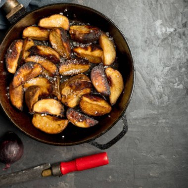 Kırsal yiyecekler. Koyu beton bir masada tavada patates kızartması. Ülke biçimi.