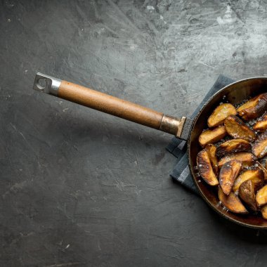 Koyu beton masada tavada patates kızartması. Ülke biçimi.