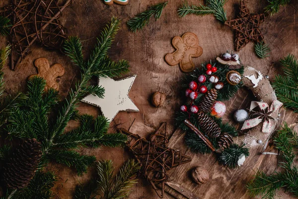 Noel gingerbreads, çam dalları ve ahşap yüzey üzerinde Noel çelenk  