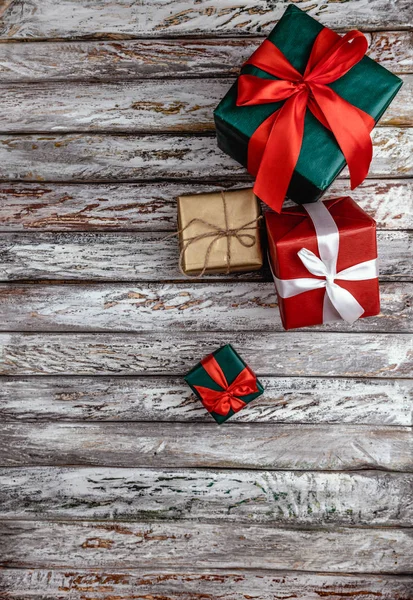 Christmas gift boxes wrapped in colorful paper on old vintage wooden background