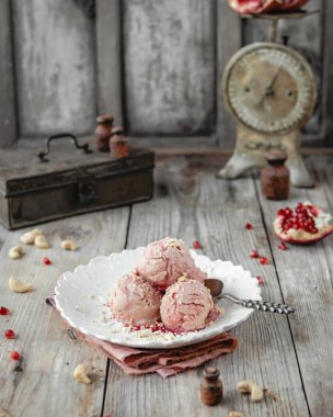 Rustik gri ahşap masa üzerinde beyaz vintage plaka üzerinde soğuk nar dondurma servis 