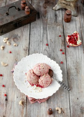 Rustik gri ahşap masa üzerinde beyaz vintage plaka üzerinde soğuk nar dondurma servis 