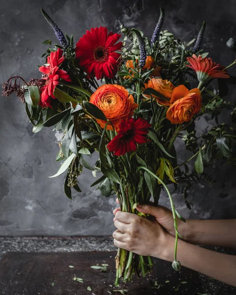 Kobiece Ręce Trzymające Świeży Wiosenny Bukiet Czerwonymi Gerberas Ranunkulyusov Zieleni — Zdjęcie stockowe