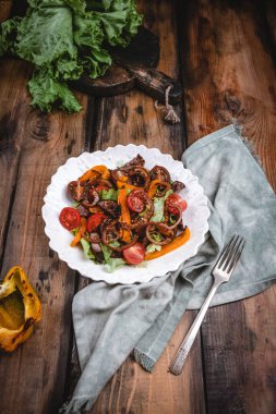 Izgara sebze, karamelize soğan ve ahşap masada kavrulmuş sığır eti ile Sıcak salata 