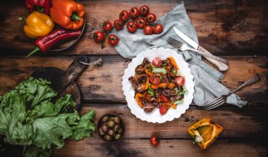 Izgara sebze, karamelize soğan ve ahşap masada kavrulmuş sığır eti ile Sıcak salata 