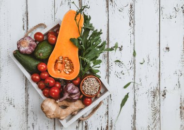 Beyaz ahşap arka plan üzerinde ayçiçeği tohumu ile beyaz ahşap kutu içinde Olgun sebze