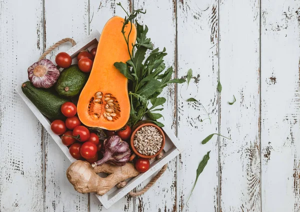 Beyaz ahşap arka plan üzerinde ayçiçeği tohumu ile beyaz ahşap kutu içinde Olgun sebze