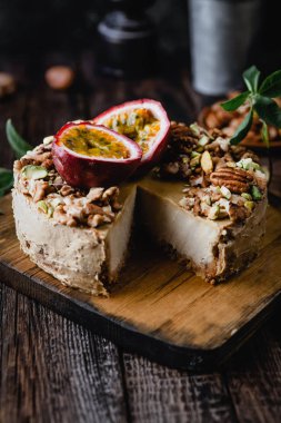 Taze ev yapımı cheesecake ahşap tahta üzerinde fındık ve maracuya ile dekore 