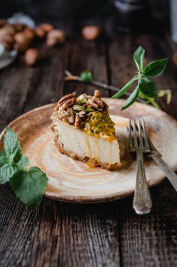 Ahşap tahta üzerinde fındık ve maracuya ile ev yapımı cheesecake parçası nın yakın görünümü
